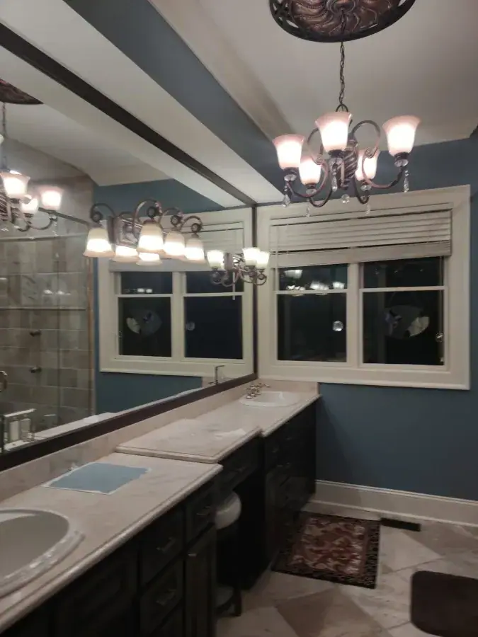 Bathroom with slate blue walls, a white ceiling beam and white window trim