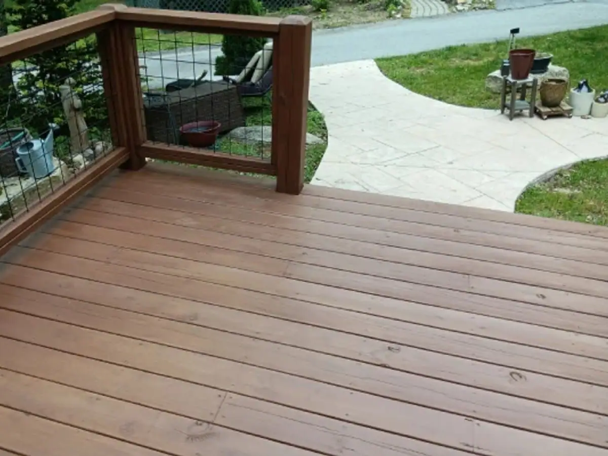 Wood deck finished in a warm brown stain, with a wire panel railing