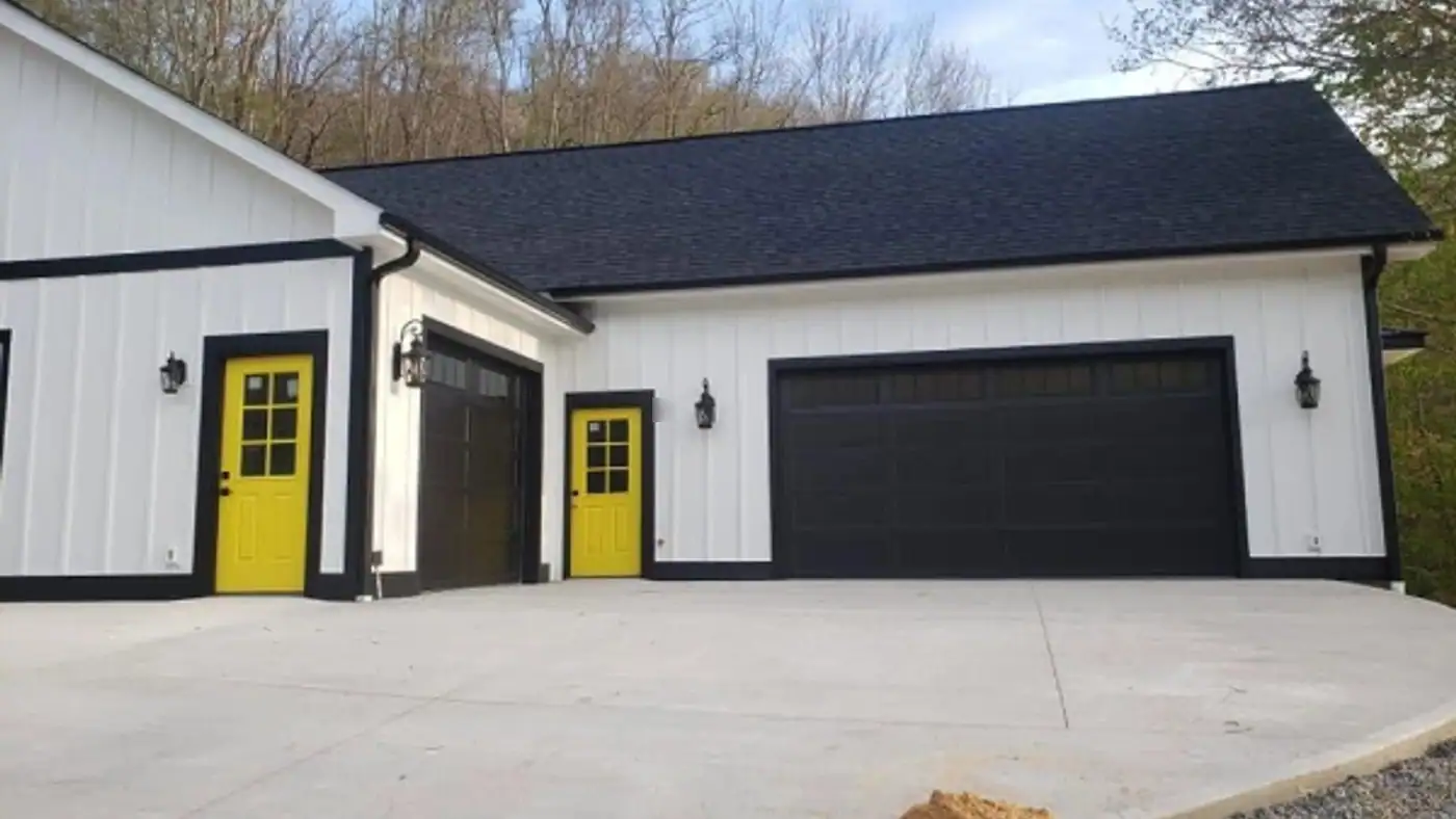 White board and batten garage with black trim, black garage doors and yellow side doors