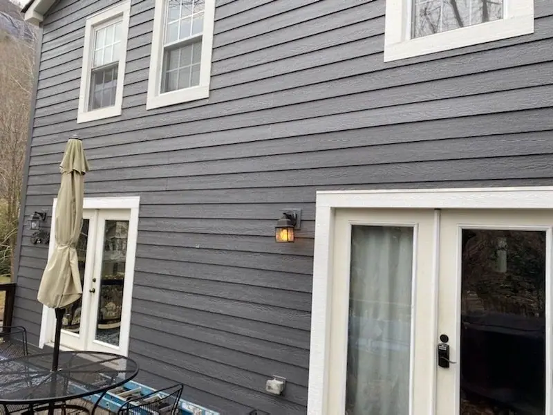 Gray lap siding and white French doors on the back of a house
